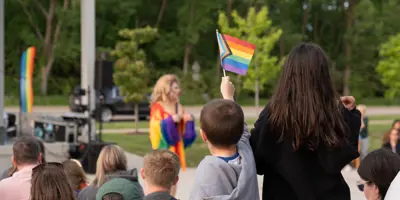 Kid holding up a pride flag at the Meridian Pride event