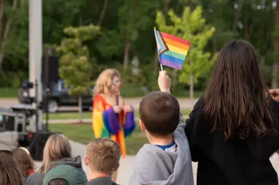 Kid holding up a pride flag at the Meridian Pride event