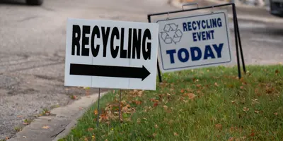 Yard signs that say "Recycling Event Today"