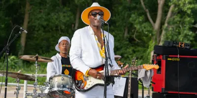 Man playing guitar and singing into microphone on a stage