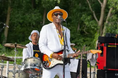 Man playing guitar and singing into microphone on a stage